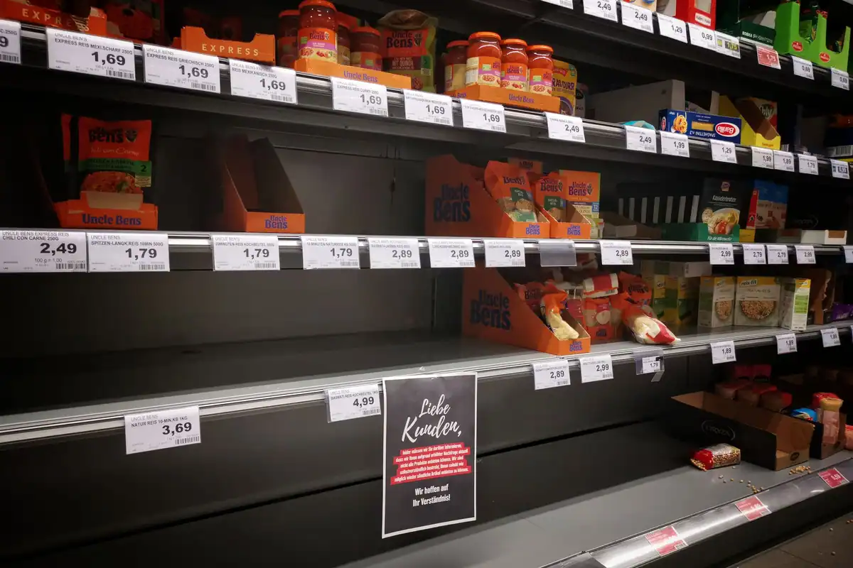 Rafturi de magazin pe jumătate goale, cu produse în borcane și recipiente
