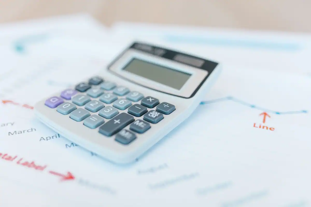 Calculator așezat pe documente financiare cu grafice și analize