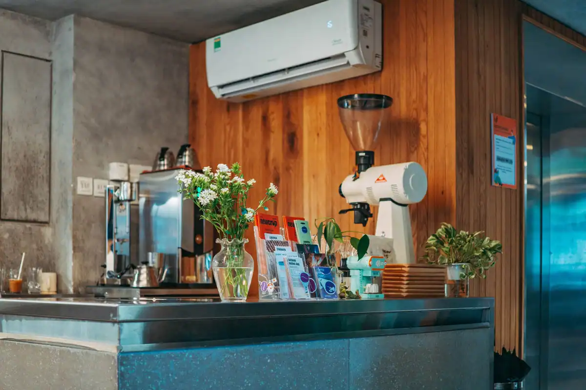 Interior de cafenea modernă cu decor din lemn și tejghea din inox