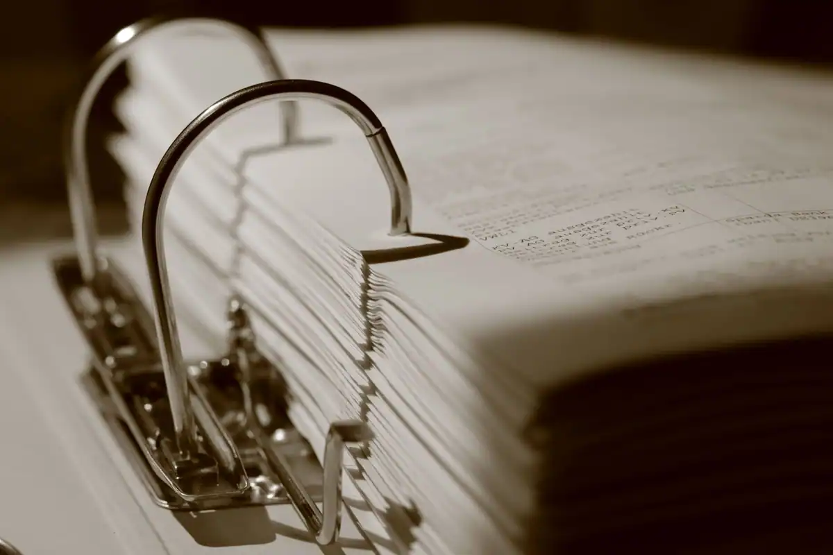 Biblioraft plin cu documente, fotografiat de aproape în tonuri sepia