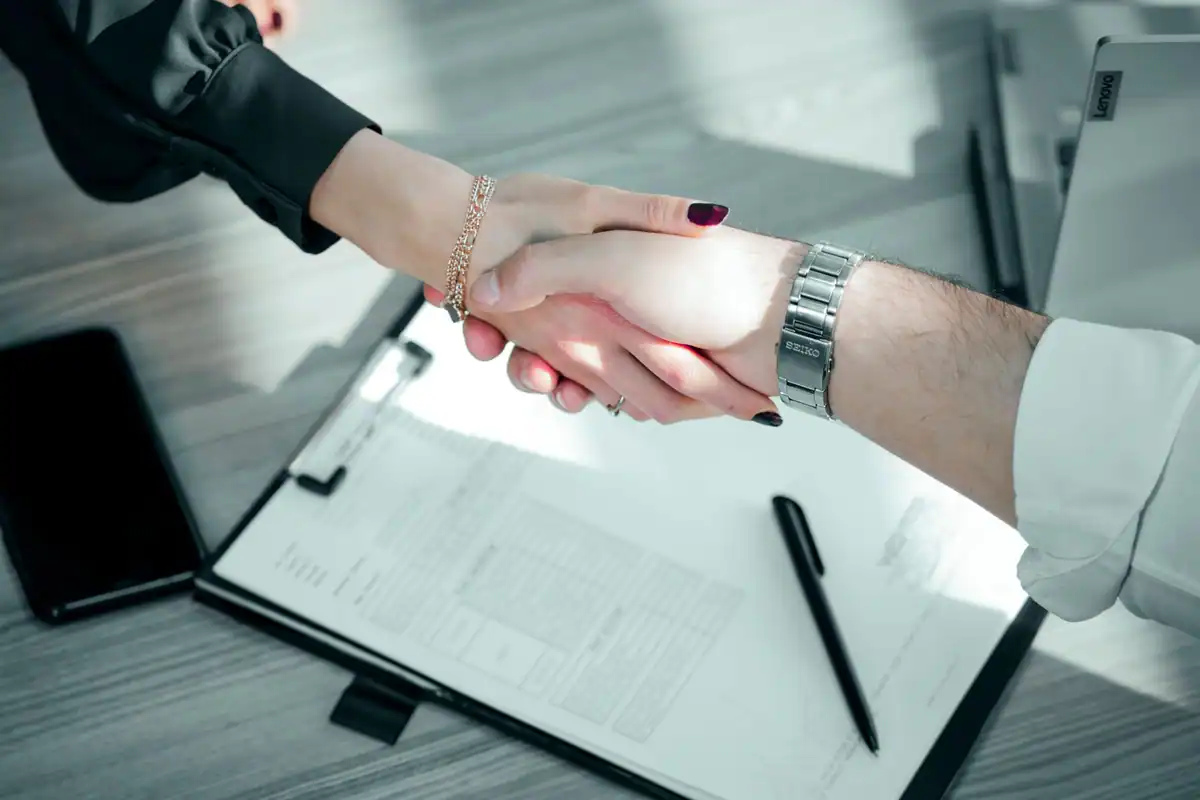 Strângere de mână deasupra unui contract semnat