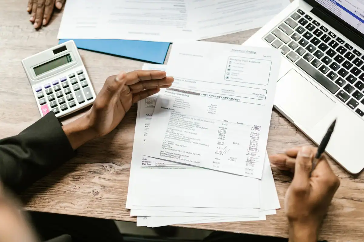 Documente financiare, calculator și laptop pe un birou de analiză